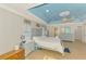 Bright main bedroom with blue tray ceiling, neutral decor, and abundant natural light at 1563 Arundel Ave, North Port, FL 34288