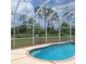 Inviting screened-in pool with an attached spa, surrounded by lush greenery, perfect for relaxation and outdoor enjoyment at 1563 Arundel Ave, North Port, FL 34288