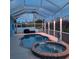 Relaxing screened pool and spa area with an outdoor grill and decorative lighting at 1563 Arundel Ave, North Port, FL 34288