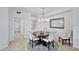 Bright dining room with a round wood table, upholstered chairs, decorative mirror, and neutral color palette at 15951 Grassland Ln # 3812, Punta Gorda, FL 33982