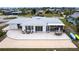 Aerial view of the home showcasing the patio, shuffleboard, and surrounding landscaping at 168 Morgan Se Ln, Port Charlotte, FL 33952