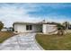 Single-story home with a decorative breeze block wall and a winding stone driveway at 168 Morgan Se Ln, Port Charlotte, FL 33952