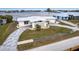 Waterfront home featuring a patterned driveway, white exterior, palm trees, and a water view at 168 Morgan Se Ln, Port Charlotte, FL 33952
