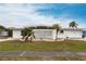Beautiful home with a white privacy wall, well-maintained lawn, and circular driveway at 168 Morgan Se Ln, Port Charlotte, FL 33952