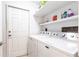 Clean laundry room equipped with a washer, dryer, and overhead storage shelves at 168 Morgan Se Ln, Port Charlotte, FL 33952