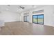 Spacious living room with sleek, light wood floors and large sliding glass doors with black frames at 17013 Alpenhorn Ct, Punta Gorda, FL 33955