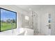 Modern bathroom featuring a glass shower, soaking tub, and a view at 17261 Naiad Ct, Punta Gorda, FL 33955
