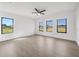 Bedroom with modern ceiling fan and three bright, sun-filled windows at 17261 Naiad Ct, Punta Gorda, FL 33955