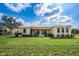 Backyard view of house showing covered patio and well maintained grass at 17261 Naiad Ct, Punta Gorda, FL 33955