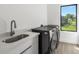 Laundry room including front load washer and dryer with sink at 17261 Naiad Ct, Punta Gorda, FL 33955