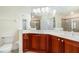 Bright bathroom featuring a double vanity with solid surface counters and framed mirrors at 17288 Acapulco Rd # 411, Punta Gorda, FL 33955