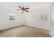 Bright bedroom features neutral tile floors, a ceiling fan, and two windows with views at 1756 Boca Raton Ct, Punta Gorda, FL 33950