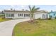 Charming home with a well-maintained front yard, a circular driveway, and mature landscaping at 1756 Boca Raton Ct, Punta Gorda, FL 33950