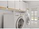 Laundry room with white cabinets, washer and dryer, and exterior door to patio at 1756 Boca Raton Ct, Punta Gorda, FL 33950