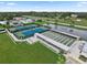 Aerial view of the community with tennis courts, shuffleboard courts, and a tranquil pond at 215 Schooner St, North Port, FL 34287