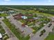 An aerial view of the clubhouse complete with pool, tennis courts and a large parking area at 215 Schooner St, North Port, FL 34287