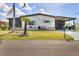 Inviting single-story home boasting a lush front lawn, complemented by a spacious driveway and shaded carport at 215 Schooner St, North Port, FL 34287