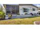 Close-up of a charming home featuring a well-maintained lawn, stylish window awnings and an enclosed porch at 215 Schooner St, North Port, FL 34287