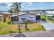 Cozy single-Gathering home with a well-kept lawn, complemented by mature palm trees and a convenient driveway at 215 Schooner St, North Port, FL 34287