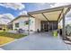 Quaint single-story home displaying a lush front yard, covered parking, and colorful awnings on the windows at 215 Schooner St, North Port, FL 34287