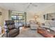 Spacious living room with comfortable seating, a plush carpet, and access to the outdoors, creating a relaxing retreat at 215 Schooner St, North Port, FL 34287