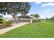 Exterior community picnic area under a pavilion is framed by grassy areas and flowering landscape at 215 Schooner St, North Port, FL 34287