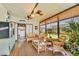 Bright and airy sunroom featuring comfortable seating, wood flooring, and multiple ceiling fans for relaxation at 215 Schooner St, North Port, FL 34287