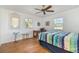Bright bedroom featuring wood floors, two windows, and a ceiling fan at 25413 Prada Dr, Punta Gorda, FL 33955