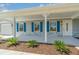 Inviting front porch with decorative blue shutters, freshly painted exterior, and manicured landscaping at 25413 Prada Dr, Punta Gorda, FL 33955