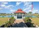 Charming red-roofed gazebo overlooking a serene pond in a beautifully landscaped community at 25413 Prada Dr, Punta Gorda, FL 33955