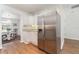 Kitchen with stainless steel refrigerator and white cabinets leading to the dining area at 25413 Prada Dr, Punta Gorda, FL 33955