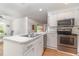 Bright kitchen showcasing white cabinetry, granite countertops, stainless steel appliances, and modern fixtures at 25413 Prada Dr, Punta Gorda, FL 33955