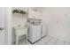 Functional laundry room with a sink, modern washer and dryer, and white cabinets at 25413 Prada Dr, Punta Gorda, FL 33955