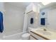 Bright bathroom featuring a shower-tub combo, floral wallpaper, and storage cabinet at 2645 W Marion Ave # 114, Punta Gorda, FL 33950