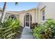 View of the home's exterior with arched doorway and lush tropical plants at 2645 W Marion Ave # 114, Punta Gorda, FL 33950