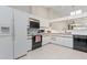 Well-lit kitchen with ample white cabinets, modern appliances, tile floors, and skylight at 2645 W Marion Ave # 114, Punta Gorda, FL 33950