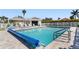 Community pool area with lounge chairs, a tiki hut, and well-maintained landscaping at 2645 W Marion Ave # 114, Punta Gorda, FL 33950