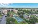 A beautiful aerial view features a community with a pool, tennis courts, and mature trees at 3006 Caring Way # 329, Port Charlotte, FL 33952