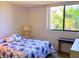 Inviting bedroom with blue floral comforter, bedside table, and a view through the window at 3006 Caring Way # 329, Port Charlotte, FL 33952