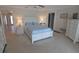Serene bedroom featuring a bed with blue bedding, bright lamps, and crisp white furniture at 32 Bariloche Dr, Punta Gorda, FL 33983