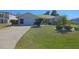 Charming home features a well-maintained lawn with tropical landscaping and a two-car garage at 32 Bariloche Dr, Punta Gorda, FL 33983