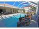 Inviting screened-in pool with spa, rock accents, and a view of the patio at 32 Bariloche Dr, Punta Gorda, FL 33983