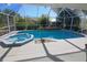 Lovely screened pool and spa with lush landscaping, perfect for outdoor relaxation at 32 Bariloche Dr, Punta Gorda, FL 33983