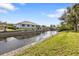 Waterfront property with a concrete seawall, lush green lawn, and views of the canal and neighboring homes at 3436 Discovery Dr, Punta Gorda, FL 33983