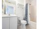 Bright bathroom featuring a shower with blue-patterned curtain, and a vanity with sink and white cabinets at 3436 Discovery Dr, Punta Gorda, FL 33983