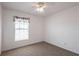 This bedroom features a window with blinds, neutral carpet, and a ceiling fan with lighting at 3436 Discovery Dr, Punta Gorda, FL 33983