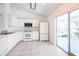 Open kitchen featuring white cabinets, appliances, and tile flooring with sliding glass doors leading to outdoor space at 3436 Discovery Dr, Punta Gorda, FL 33983