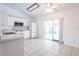 A modern, all-white kitchen featuring tile flooring, stainless steel appliances, and a sliding glass door to patio at 3436 Discovery Dr, Punta Gorda, FL 33983