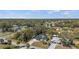 An aerial view shows a quiet residential area with lush greenery and diverse architectural styles under a blue sky at 3956 Fairchild Ave, North Port, FL 34287