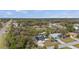 An aerial view showcases residential homes nestled among mature trees in a serene neighborhood on a sunny day at 3956 Fairchild Ave, North Port, FL 34287
